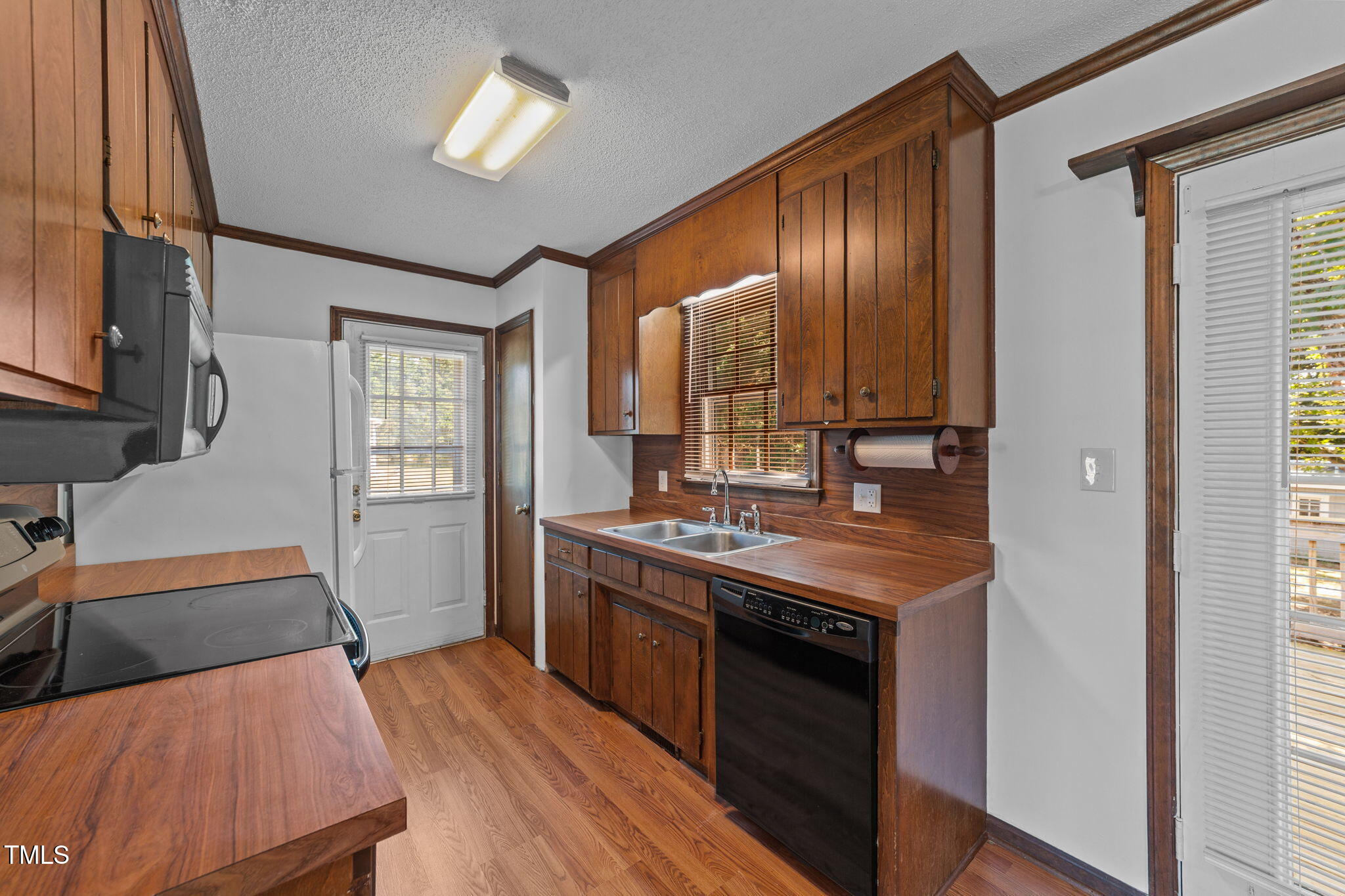 1101 Robinfield Drive Raleigh, NC 27603 - Photo 10 of 48 a kitchen that has a sink a stove and wooden floor
