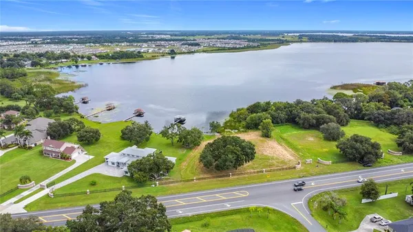 an aerial view of lake residential house with swimming pool and outdoor space