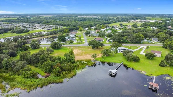an aerial view of a houses with a yard and lake view