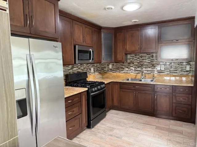 a kitchen with stainless steel appliances granite countertop a refrigerator stove and cabinets
