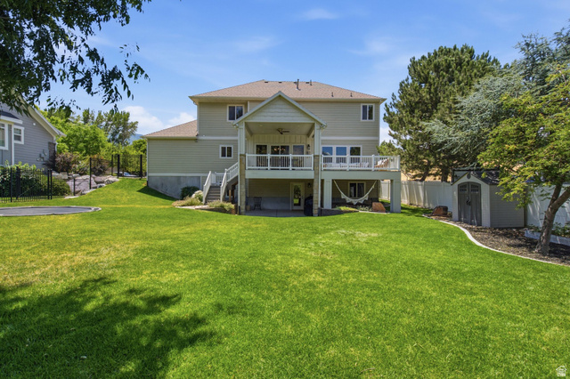 1263 East 1200th South Springville, UT 84663 - Photo 51 of 60 Spacious rear yard with a tiered design, featuring an upper deck with white railing, a covered lower patio, and a storage shed