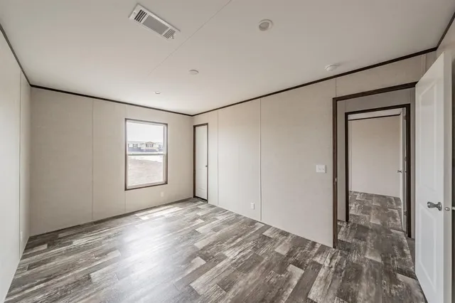 an empty room with windows and closet