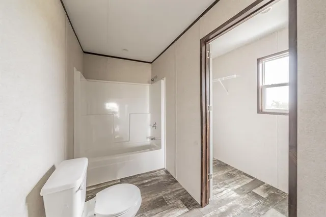 a bathroom with a toilet and a shower