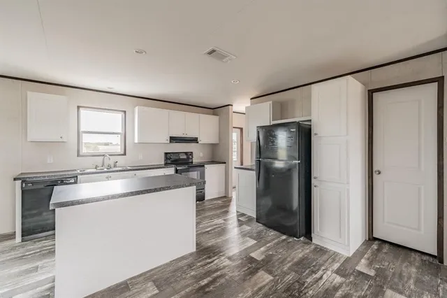 a kitchen with a refrigerator sink and cabinets