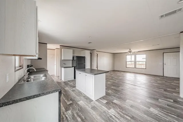 a kitchen with granite countertop a stove a sink and a refrigerator