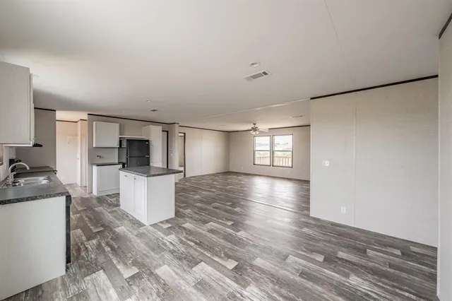 a view of a kitchen with a sink a refrigerator and cabinets