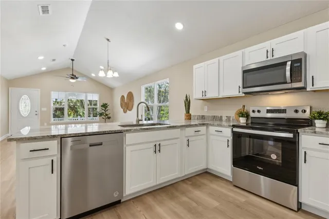 a kitchen with sink a microwave and cabinets