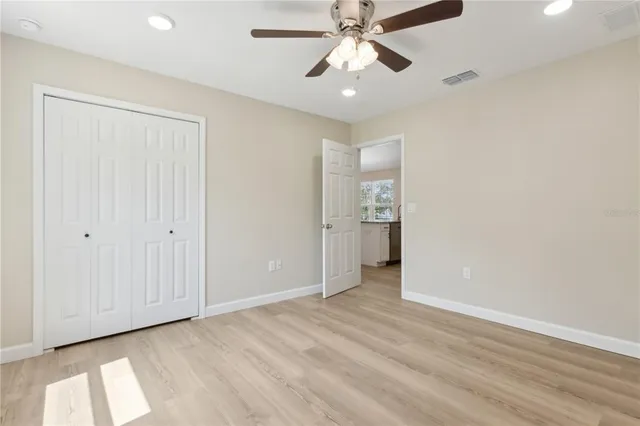 an empty room with fan and entrance