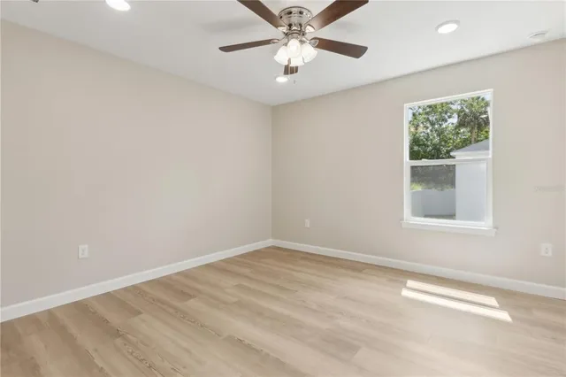 an empty room with a window and a fan