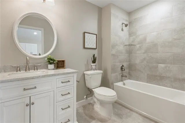 a bathroom with a toilet a sink a mirror and bathtub