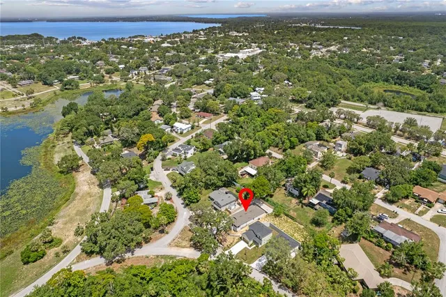 an aerial view of residential houses with outdoor space and trees