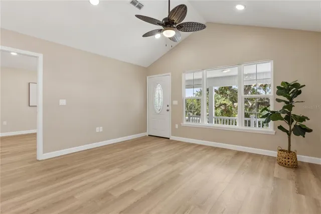 a view of an empty room with a window and a ceiling fan