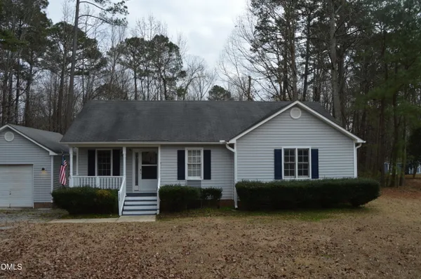 a view of a house with a yard and large trees