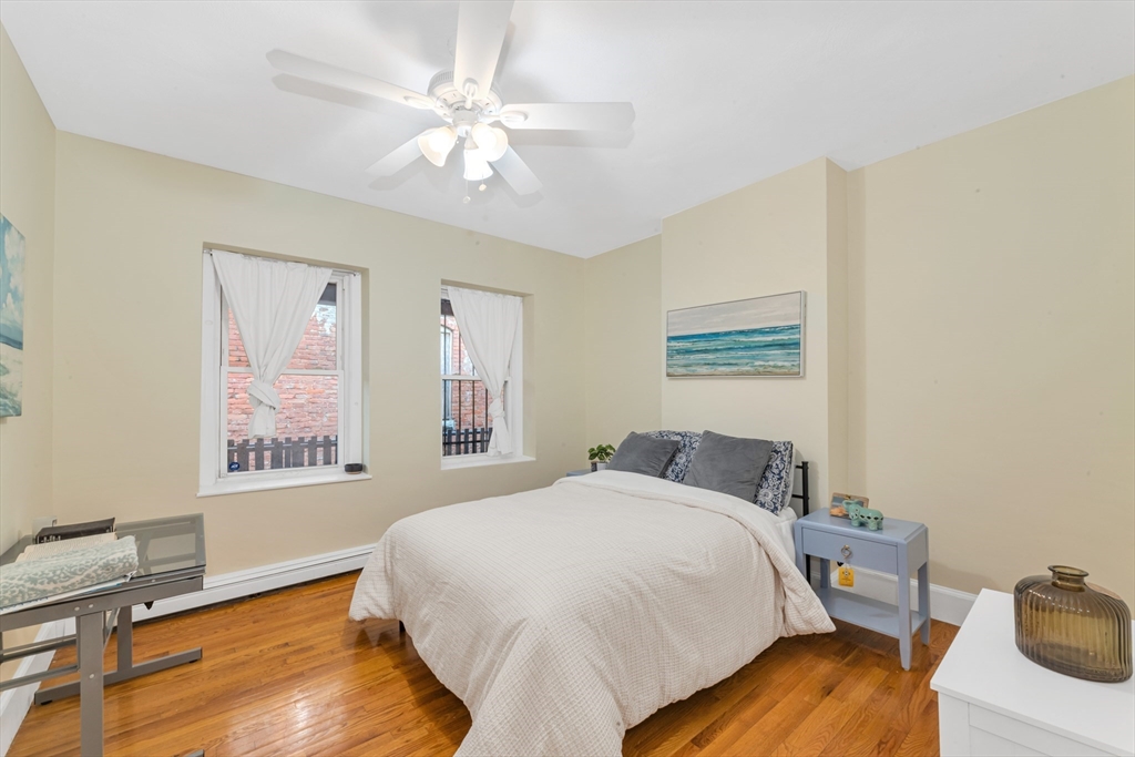 122 Day Street, Unit 3 Boston, MA 02130 - Photo 12 of 14 a bedroom with a bed and a chandelier