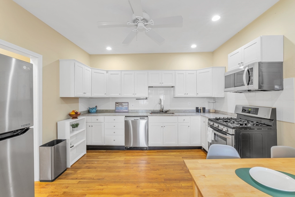 122 Day Street, Unit 3 Boston, MA 02130 - Photo 6 of 14 a large kitchen with stainless steel appliances granite countertop a stove a sink a refrigerator and white cabinets