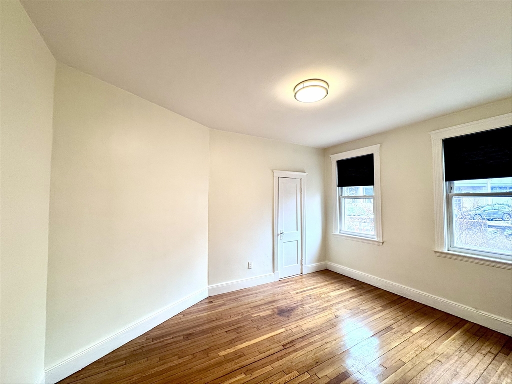 28 Sidlaw Road, Unit 2 Boston, MA 02135 - Photo 2 of 8 a view of an empty room with wooden floor and a window