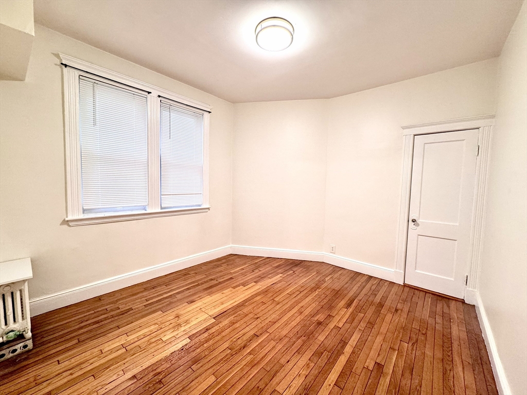 28 Sidlaw Road, Unit 2 Boston, MA 02135 - Photo 3 of 8 an empty room with wooden floor and windows