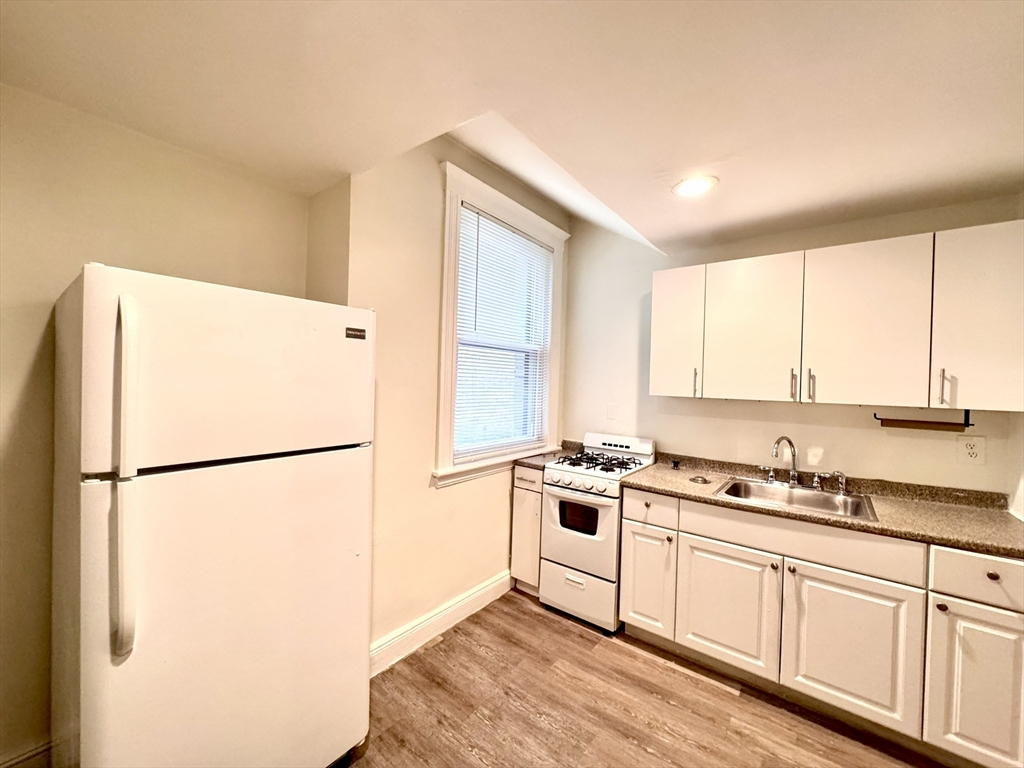 28 Sidlaw Road, Unit 2 Boston, MA 02135 - Photo 4 of 8 a kitchen with a refrigerator a stove a sink and a window