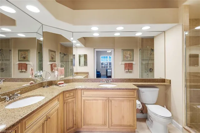 a bathroom with a granite countertop toilet sink and mirror