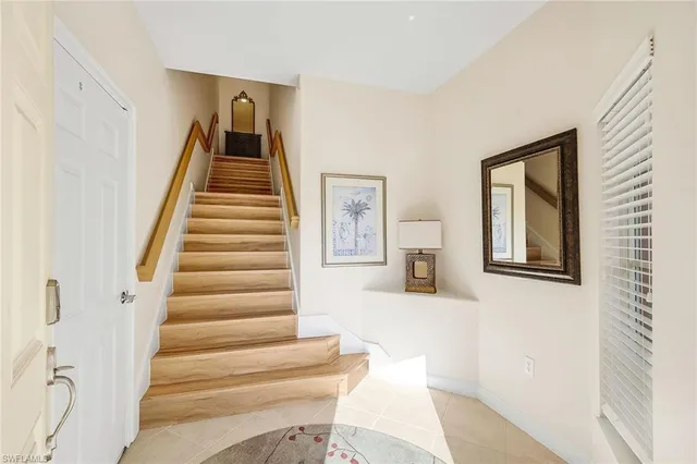 a view of staircase with lots of frames on wall and a large window