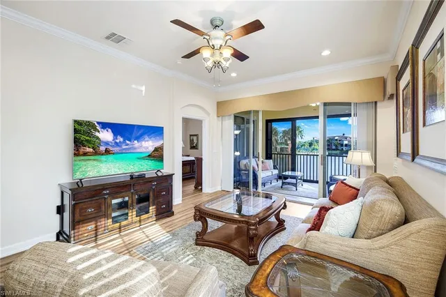 a living room with furniture a flat screen tv and a floor to ceiling window