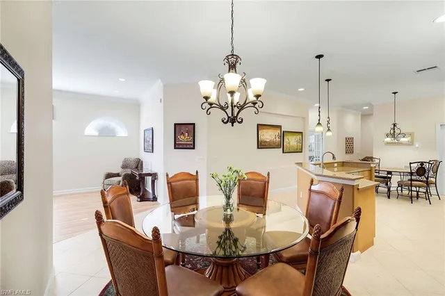 a dining room with wooden floor a chandelier a wooden table and chairs