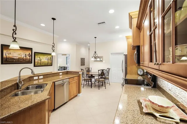 a open kitchen with stainless steel appliances granite countertop a sink a stove and a refrigerator with wooden floor
