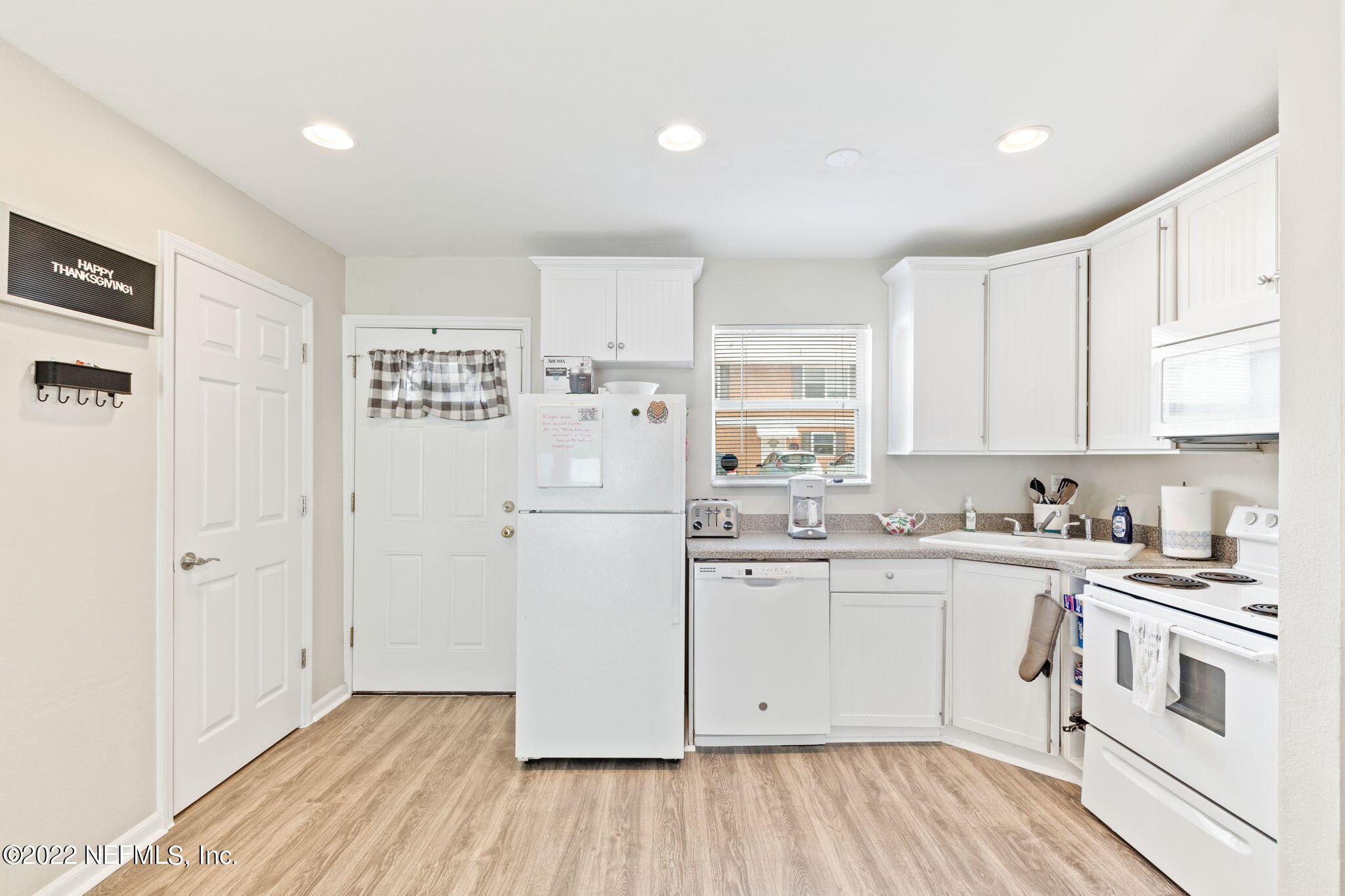 4420 Carter Road, Unit 5 St. Augustine, FL 32086 - Photo 19 of 29 a kitchen with white cabinets and white appliances