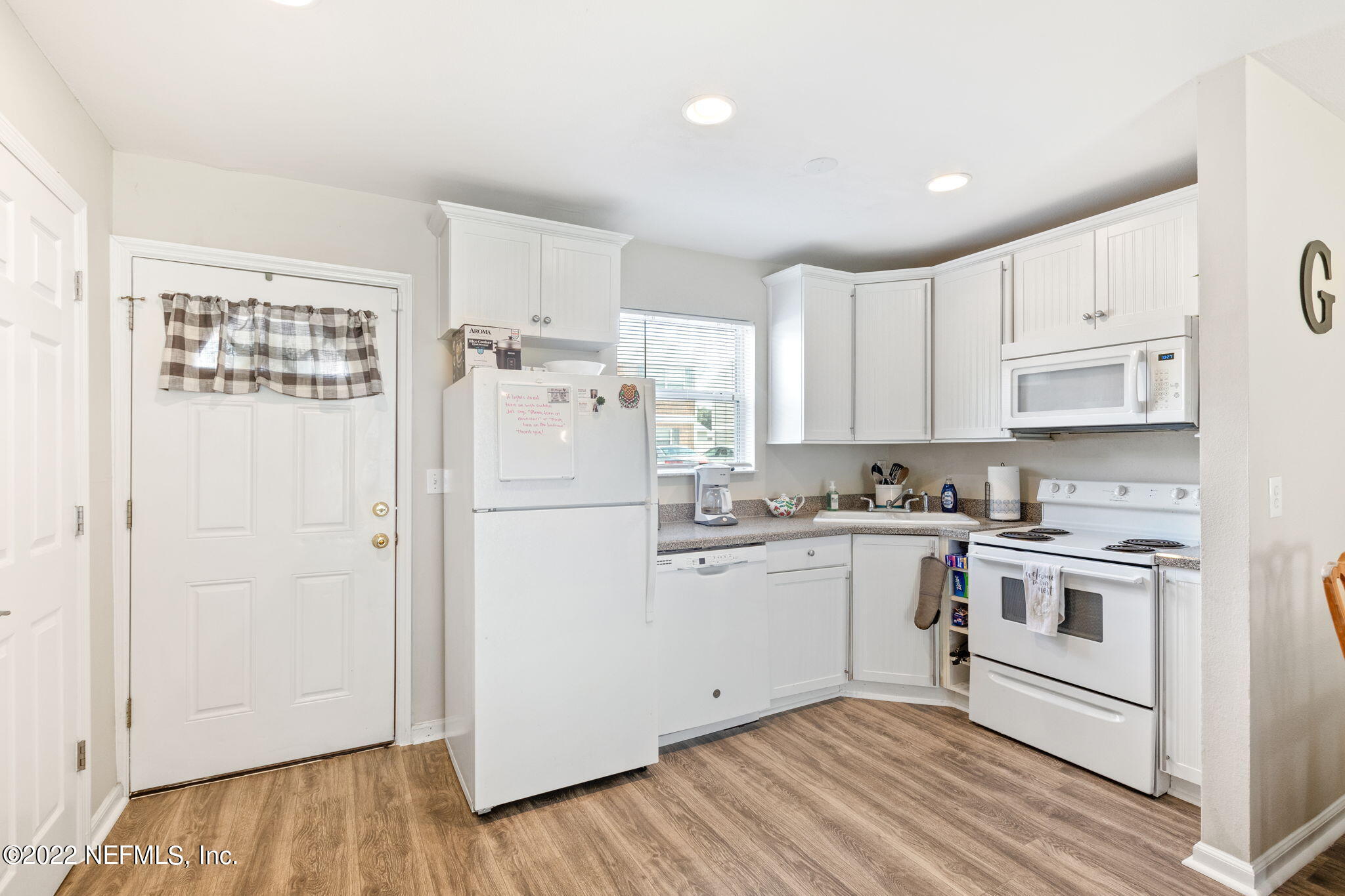 4420 Carter Road, Unit 5 St. Augustine, FL 32086 - Photo 4 of 29 a kitchen with white cabinets and white appliances