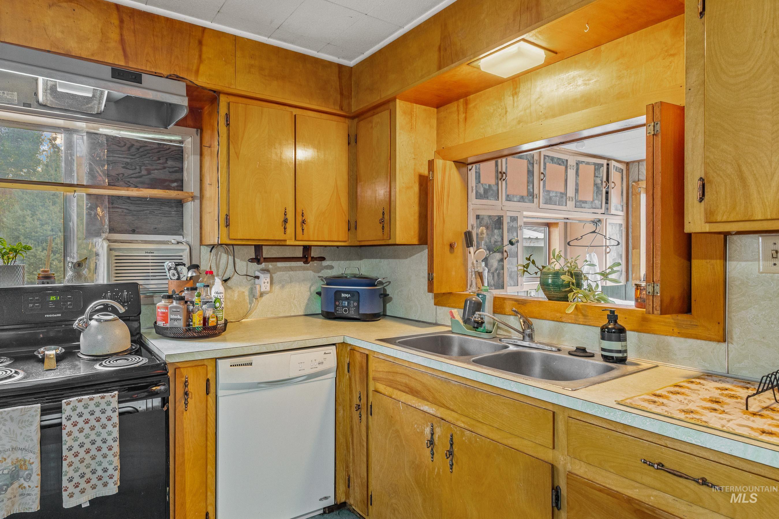 620 South Main Street Riggins, ID 83549 - Photo 5 of 23 Laminate countertops with a double basin sink, wood cabinetry, and a pass-through window