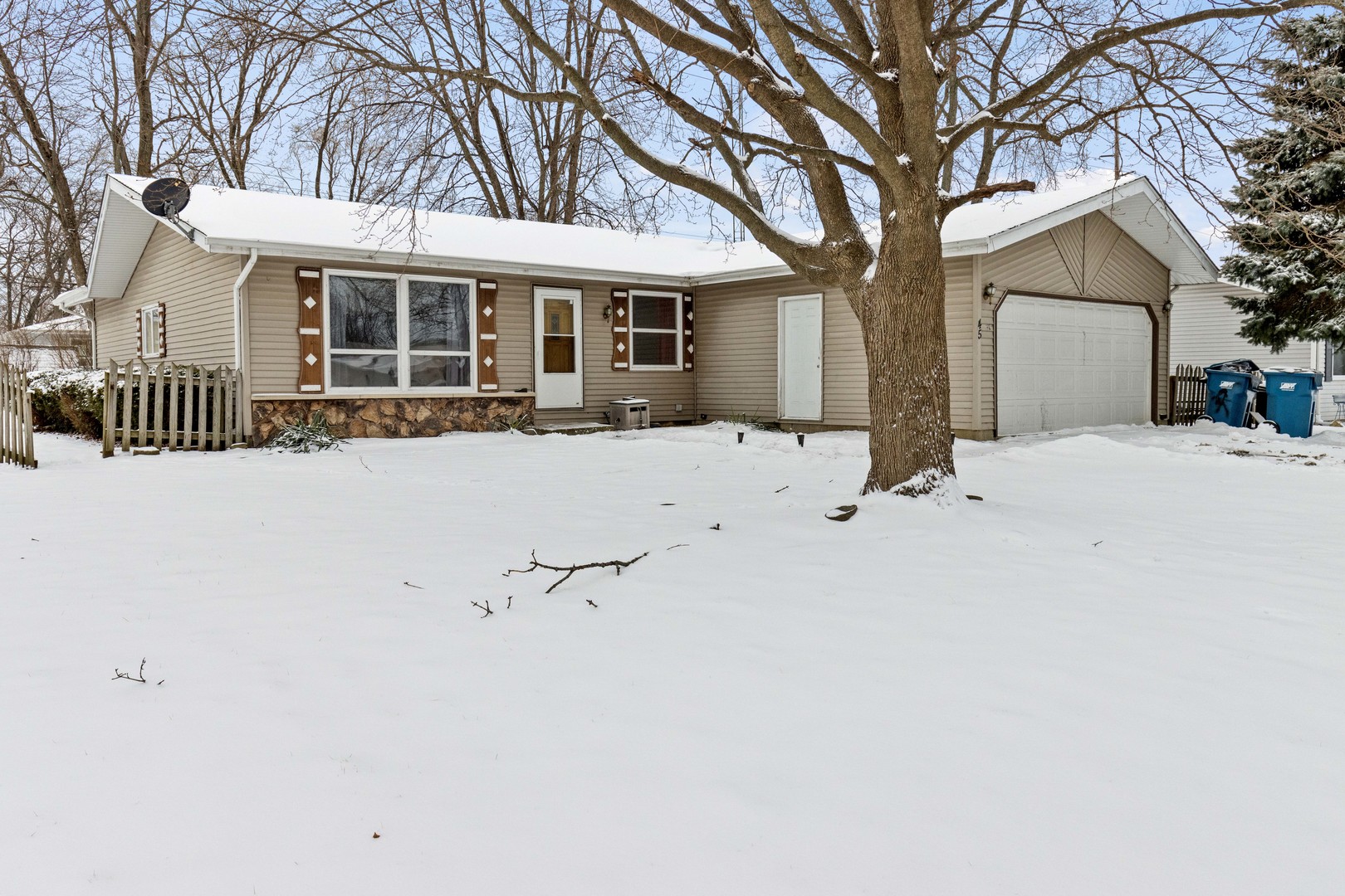 front view of house with a yard covered in snow