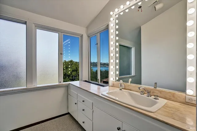 a white toilet sitting next to a white sink and vanity
