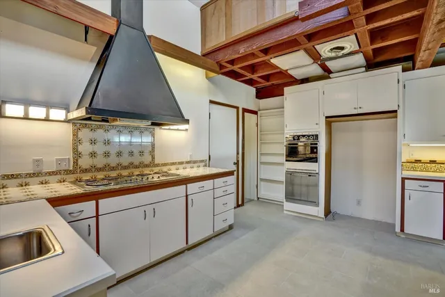 a kitchen with stainless steel appliances granite countertop a sink a stove and a wooden floors
