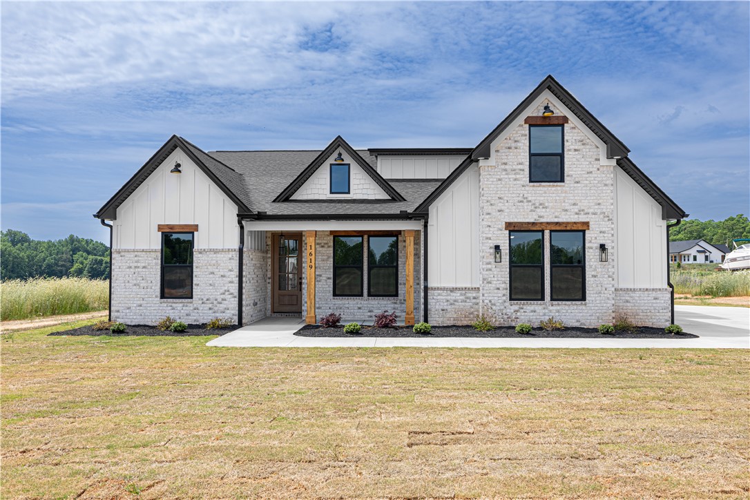 This modern farmhouse features striking gables and a welcoming covered porch, perfect for outdoor living.