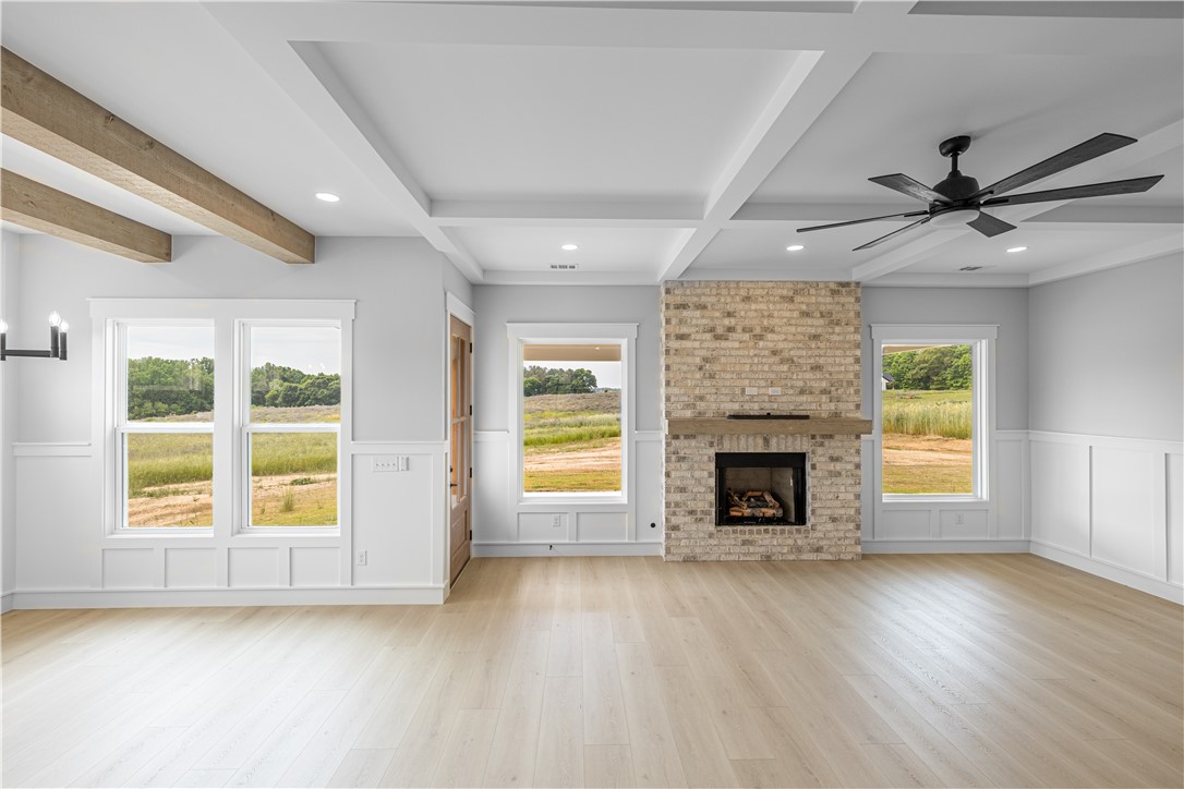1619 Old Dobbins Bridge Road Townville, SC 29689 - Photo 13 of 34 This expansive living area features architectural beams, a fireplace, and views of the surrounding landscape.