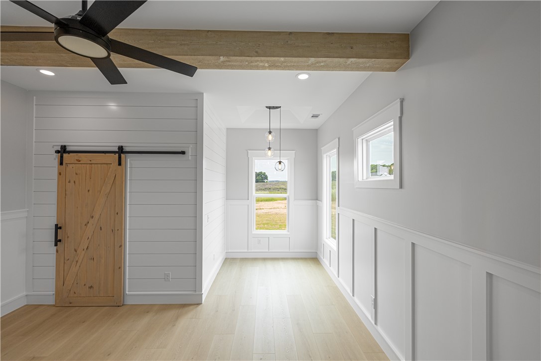 1619 Old Dobbins Bridge Road Townville, SC 29689 - Photo 30 of 34 This bright space features a barn door and exposed beam, creating a rustic yet modern aesthetic.