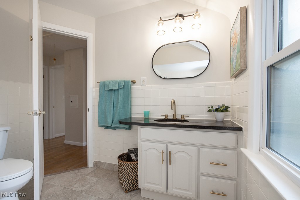 3762 Covington Road South Euclid, OH 44121 - Photo 24 of 31 Bathroom with tile walls, vanity, wainscoting, and light tile patterned floors