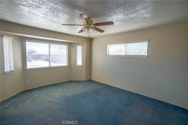 an empty room with a ceiling fan and window
