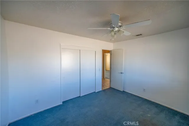 an empty room with fan and windows