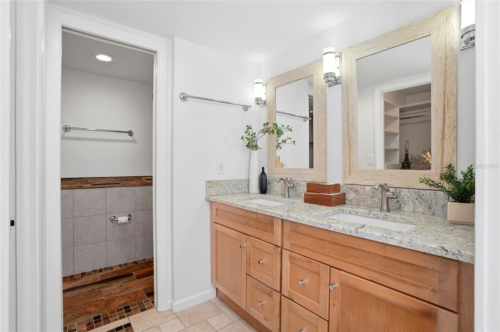 16308 Gulf Boulevard, Unit 303 Redington Beach, FL 33708 - Photo 27 of 42 a bathroom with a granite countertop sink and a mirror