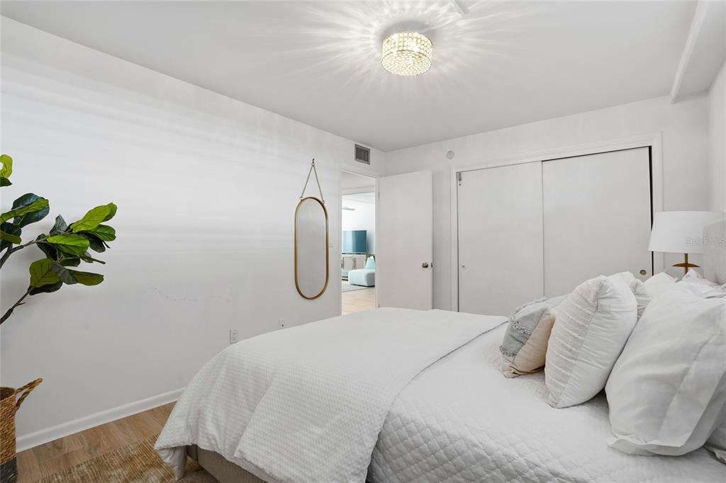 16308 Gulf Boulevard, Unit 303 Redington Beach, FL 33708 - Photo 32 of 42 a bedroom with a bed and a potted plant