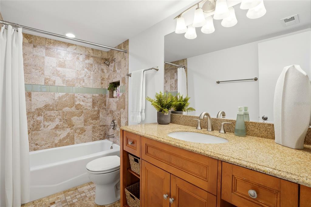 16308 Gulf Boulevard, Unit 303 Redington Beach, FL 33708 - Photo 33 of 42 a bathroom with a granite countertop sink a toilet and bathtub