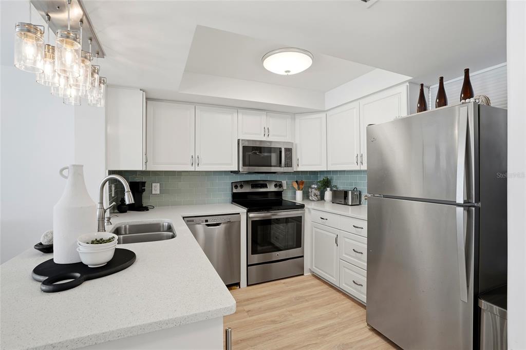 16308 Gulf Boulevard, Unit 303 Redington Beach, FL 33708 - Photo 7 of 42 a kitchen with refrigerator a microwave and cabinets