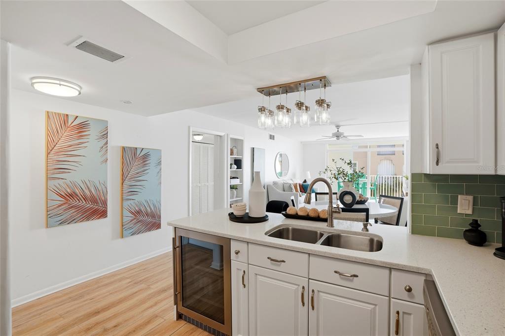 16308 Gulf Boulevard, Unit 303 Redington Beach, FL 33708 - Photo 8 of 42 a kitchen with stainless steel appliances a white cabinets and wooden floor