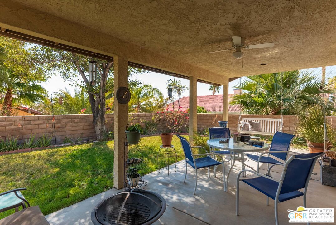 9760 Capiland Road Desert Hot Springs, CA 92240 - Photo 14 of 16 a view of a patio with table and chairs potted plants with wooden floor and fence