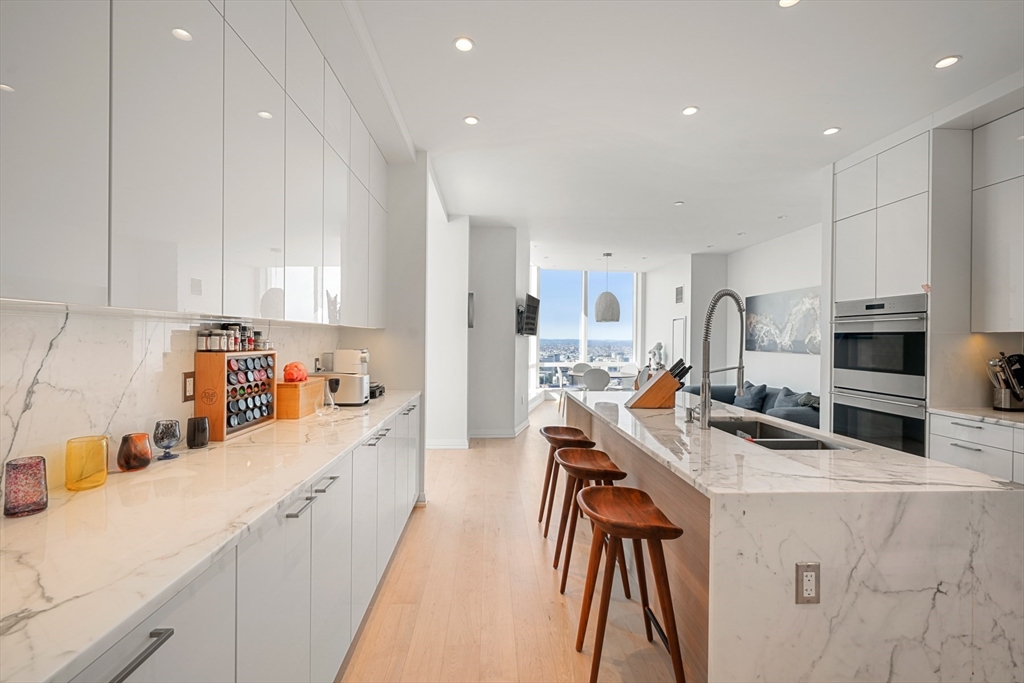 1 Franklin Street, Unit 4802 Boston, MA 02110 - Photo 12 of 42 a kitchen with stainless steel appliances a sink a stove a refrigerator cabinets and a counter top space