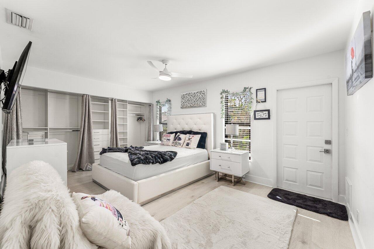 5300 Nesting Way, Unit A Delray Beach, FL 33484 - Photo 14 of 53 a bedroom with a bed large window and wall painting