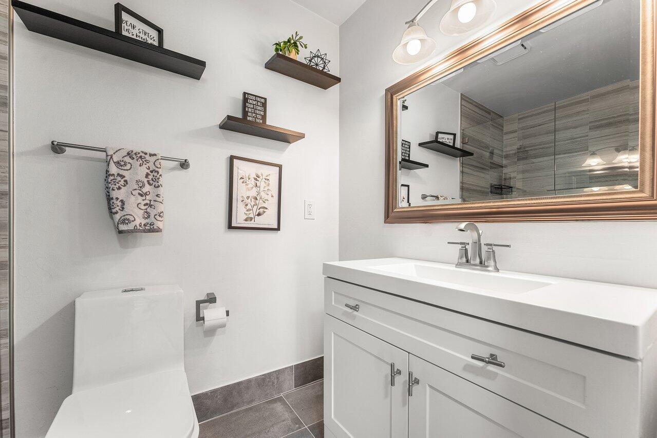 5300 Nesting Way, Unit A Delray Beach, FL 33484 - Photo 21 of 53 a bathroom with a toilet sink and mirror