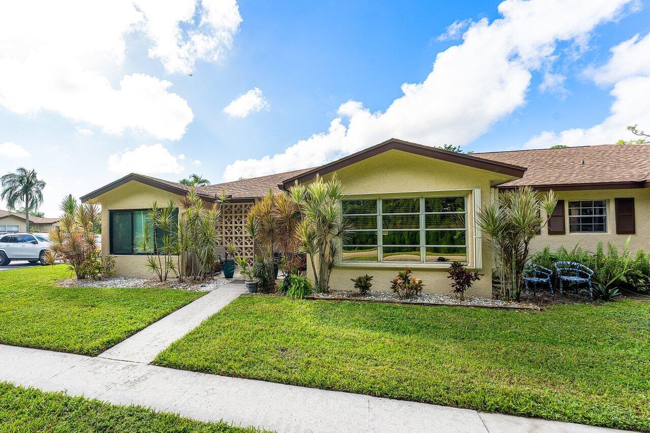 5300 Nesting Way, Unit A Delray Beach, FL 33484 - Photo 22 of 53 a front view of a house with a yard