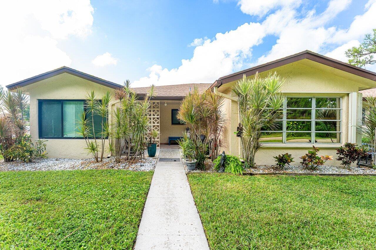 5300 Nesting Way, Unit A Delray Beach, FL 33484 - Photo 23 of 53 a front view of a house with a yard